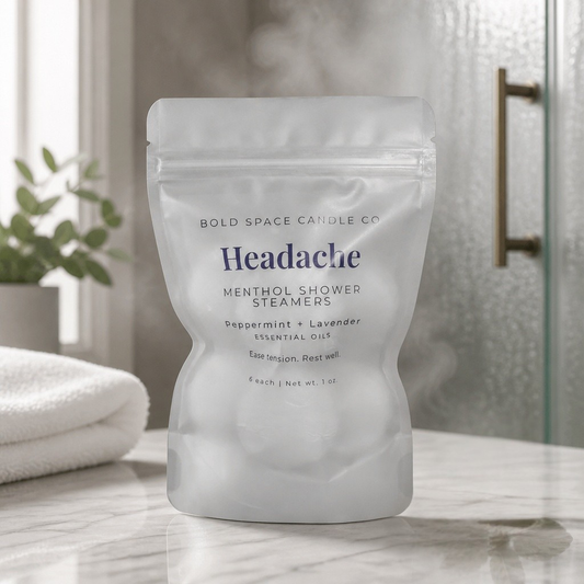 Package of 'Headache' shower steamers on a bathroom counter with steam in the background
