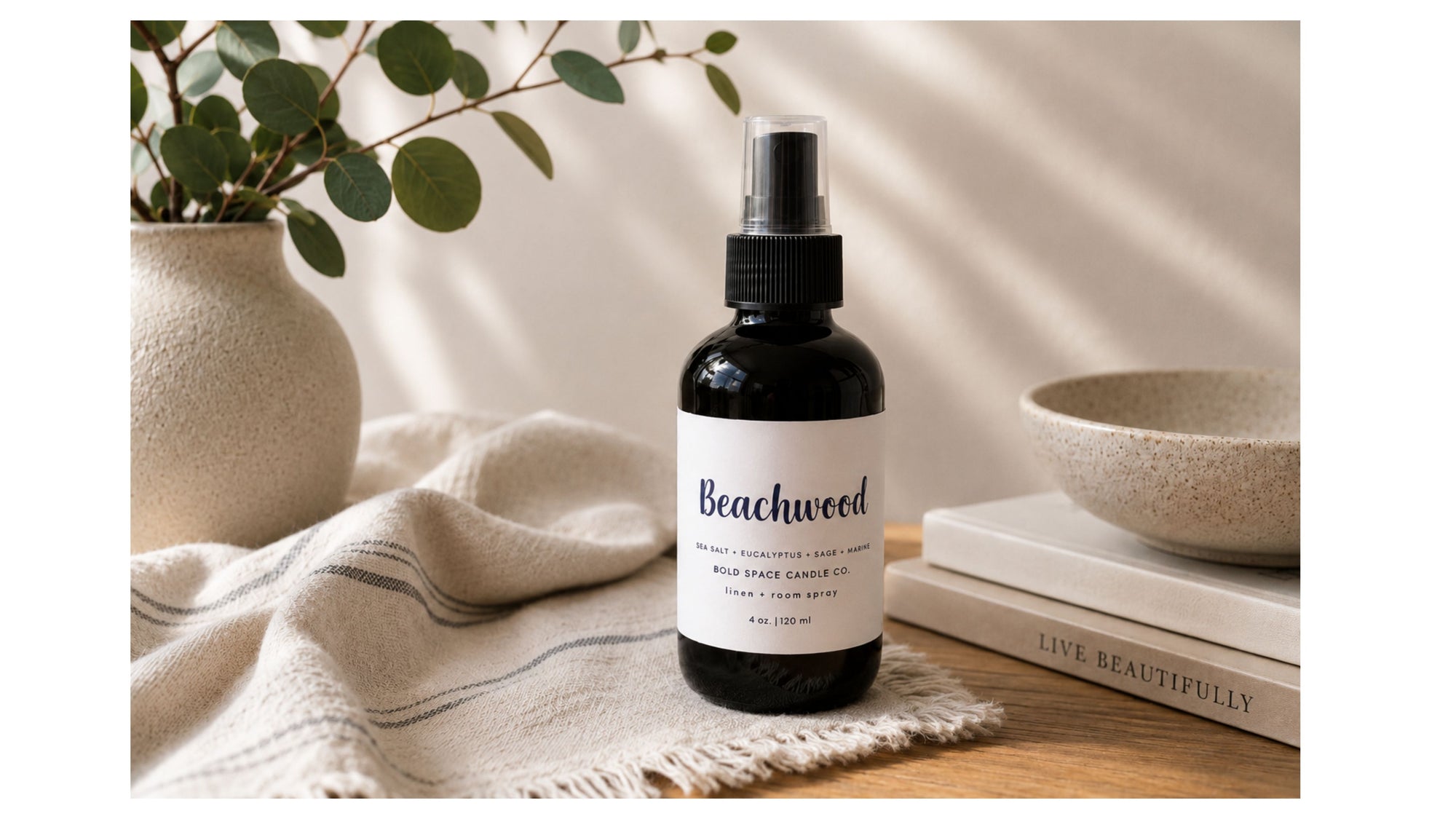 Black bottle with white label that says beachwood linen spray