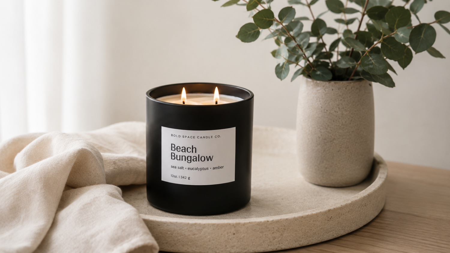 large black candle with white label that reads beach bungalow 