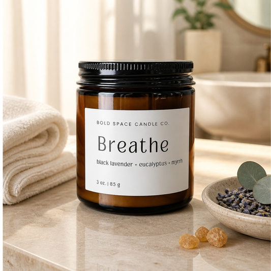 Candle labeled 'Breathe' by Bold Space Candle Co. on a bathroom counter with lavender and myrrh.