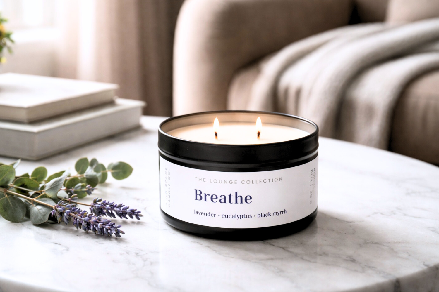 Candle labeled 'Breathe' on a marble table with lavender and books in the background