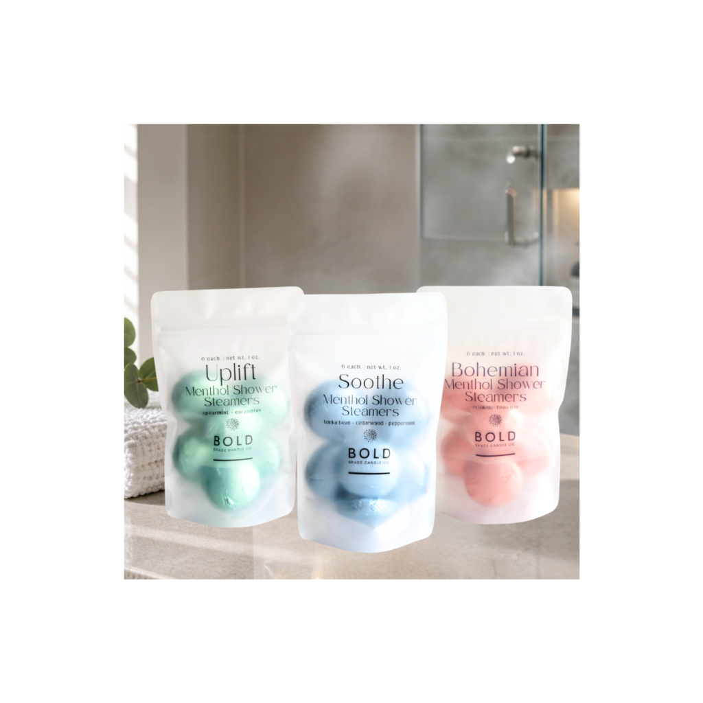 Three shower steamers in packaging on a bathroom counter.