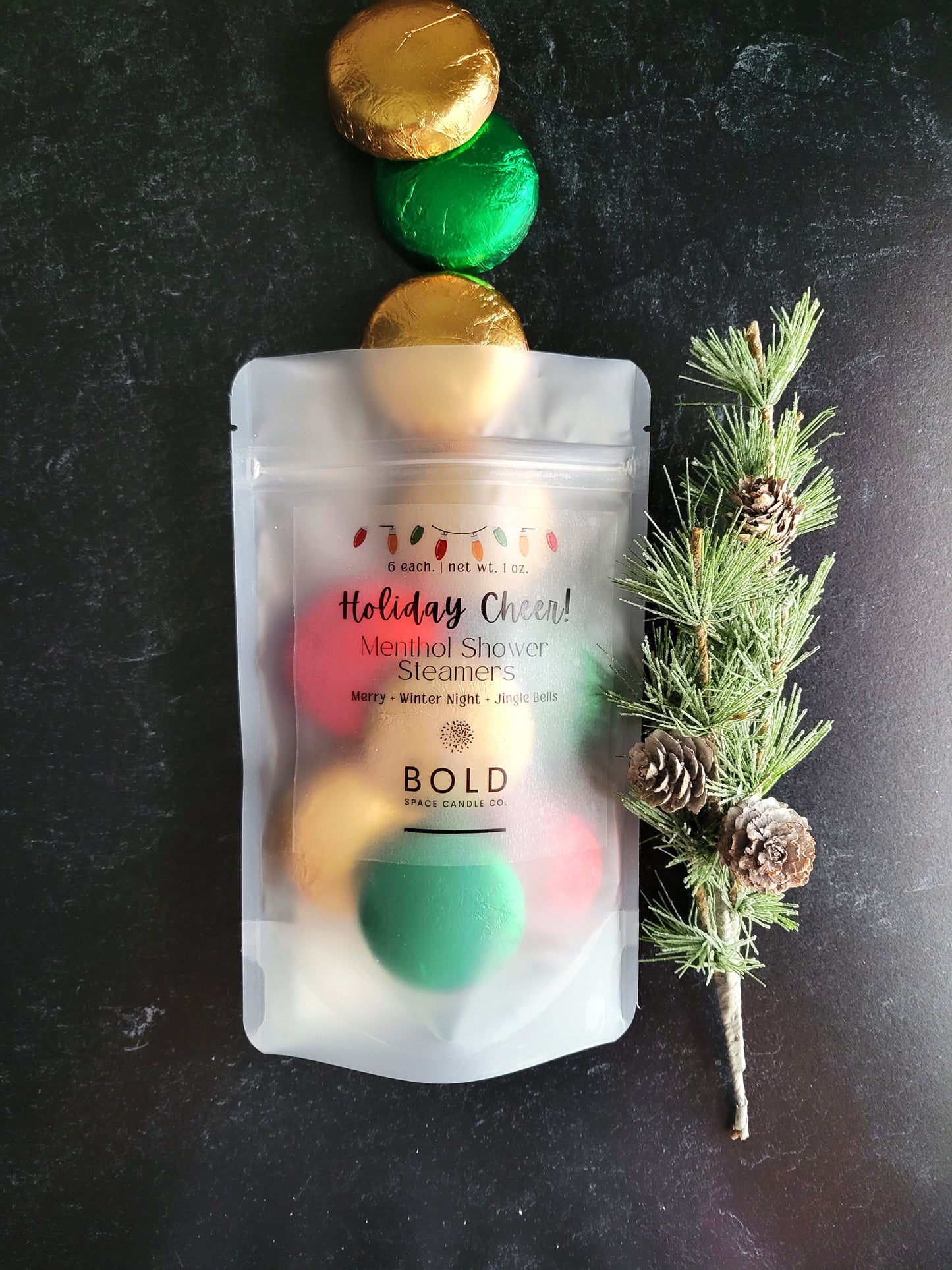  holiday-themed shower steamers 
packaging with colorful elements on a dark background