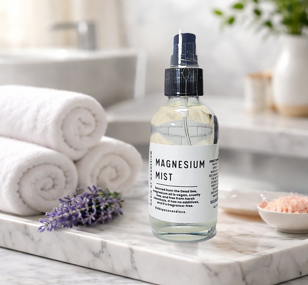 Bottle of magnesium mist on a marble surface with towels and lavender in the background